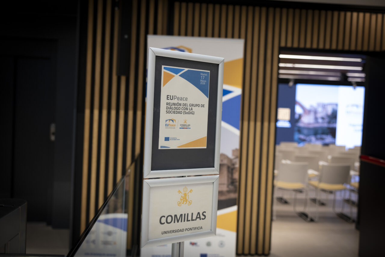 A sign inside a conference venue showing information about the EUPeace meeting at Comillas University.