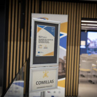 A sign inside a conference venue showing information about the EUPeace meeting at Comillas University.
