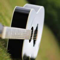 A classical guitar lying on the grass.