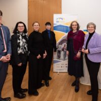 Members of the EUPeace delegation standing in front of an EUPeace roll-up at the Brussels lunch debate.