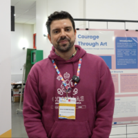 A person standing in front of banners for the EUPeace Teaching Europe Conference 2025. The person is Jesús Muñoz Muñoz.