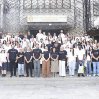 A large group of people standing in front of a building of the University of Prishtina. The group is the organising team of the Prishtina Summer School.