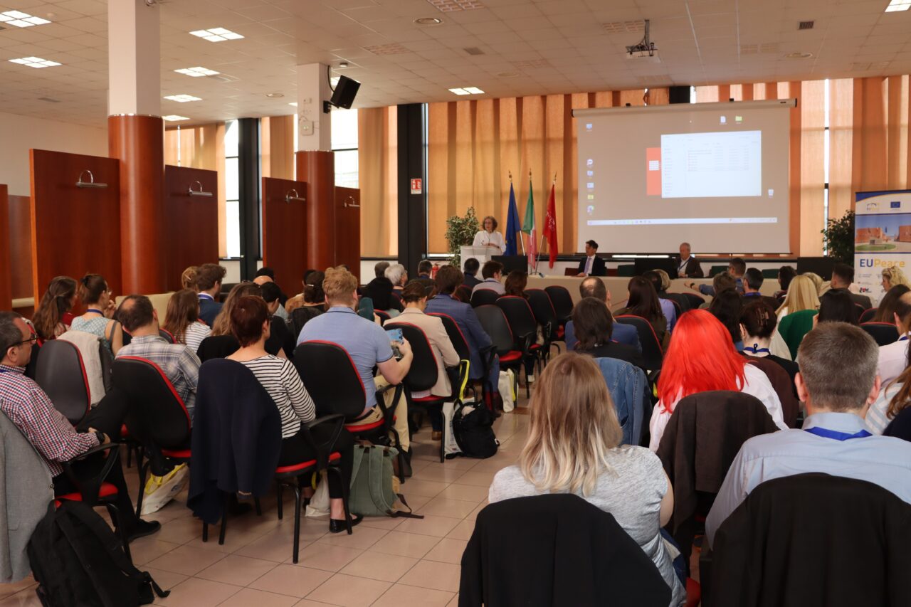 A woman holding a presentation in front of an audience. The woman is Evelyn Korn.