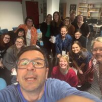 A group of people posing for a selfie. A man is taking the picture.