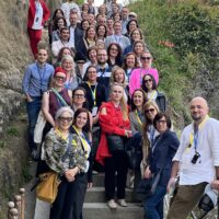 Participants of the event posing for a group photo, standing on steps.
