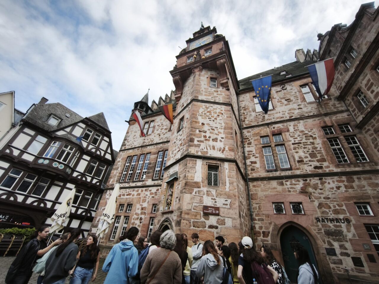 A group of pre-service teachers and colleagues from the University of Limoges, standing in front of the Town Hall of Marburg, Germany.