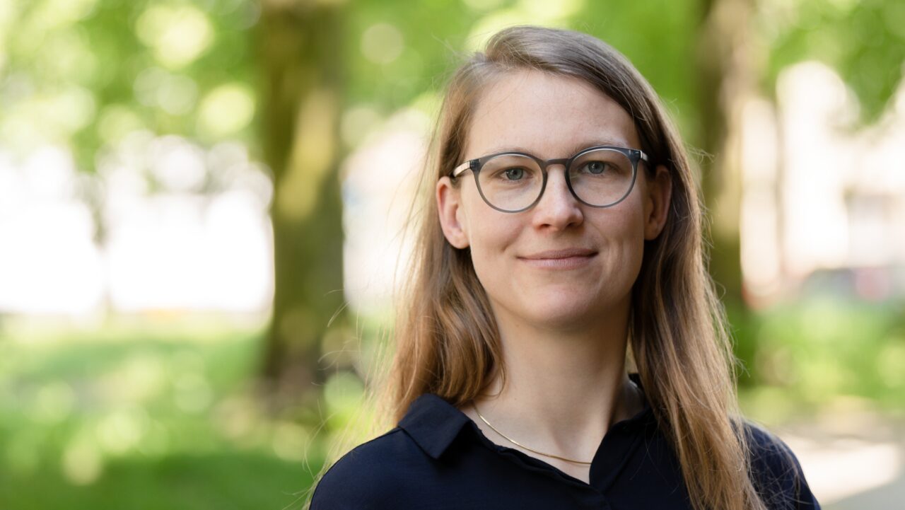 A portrait of a woman with blurry trees in the background. The woman is Prof. Dr Ulrike Gisch.