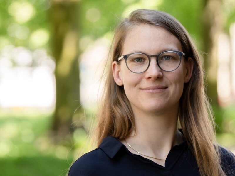 A portrait of a woman with blurry trees in the background. The woman is Prof. Dr Ulrike Gisch.