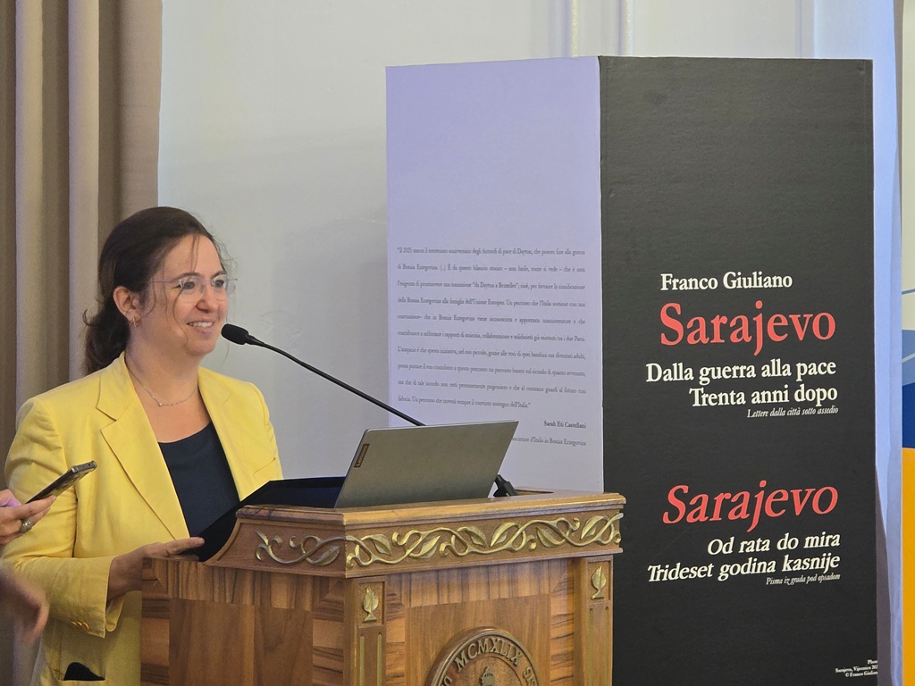 A person standing behind a podium, speaking into the microphone. The person is Italian Ambassador to Bosnia and Herzegovina, Sarah Eti Castellani.