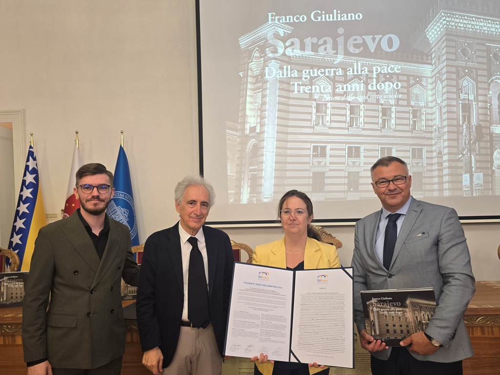 Four persons posing for a photo, holding the signed Students' Peace Declaration 2025. The persons are from left to right Imran Pašalić, Franco Giualiano, Sarah Eti Castellani and Kemal Durić.