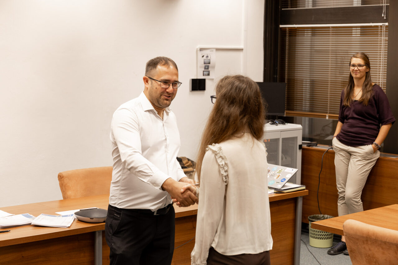 Markéta Ondříčková, a law student at the UWB, being congratulated with a handshake by a university representative.