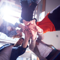 happy students celebrate, friends group together at school, young people raise hands, stack and get in circle formation together