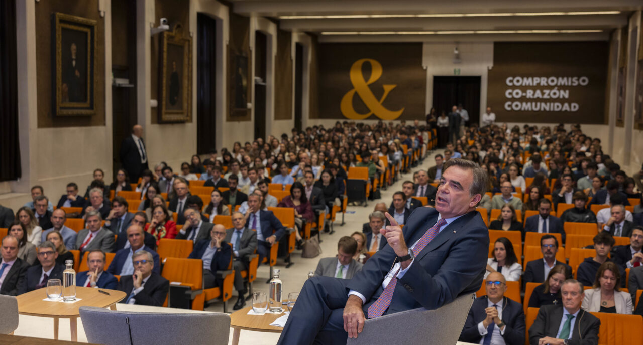 Margaritis Schinas speaks at Comillas Pontifical University during the presentation of the Chair on Strategic Autonomy Studies, with attendees and speakers visible in the background.