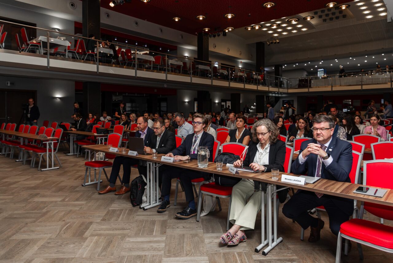 An audience in big room listens to the keynote speeches