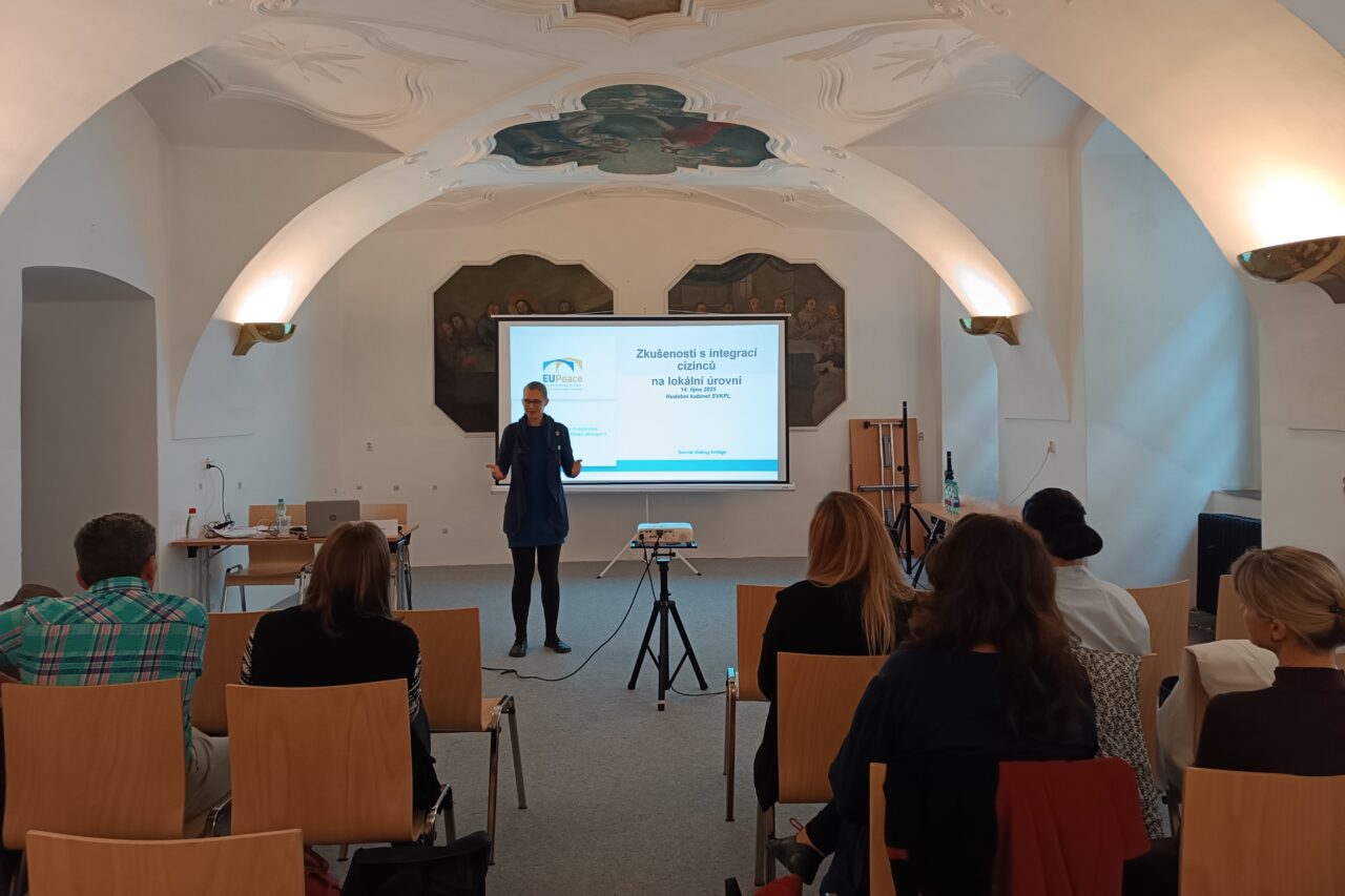 A woman is giving a lecture on Czech approach to integration of foreigners.
