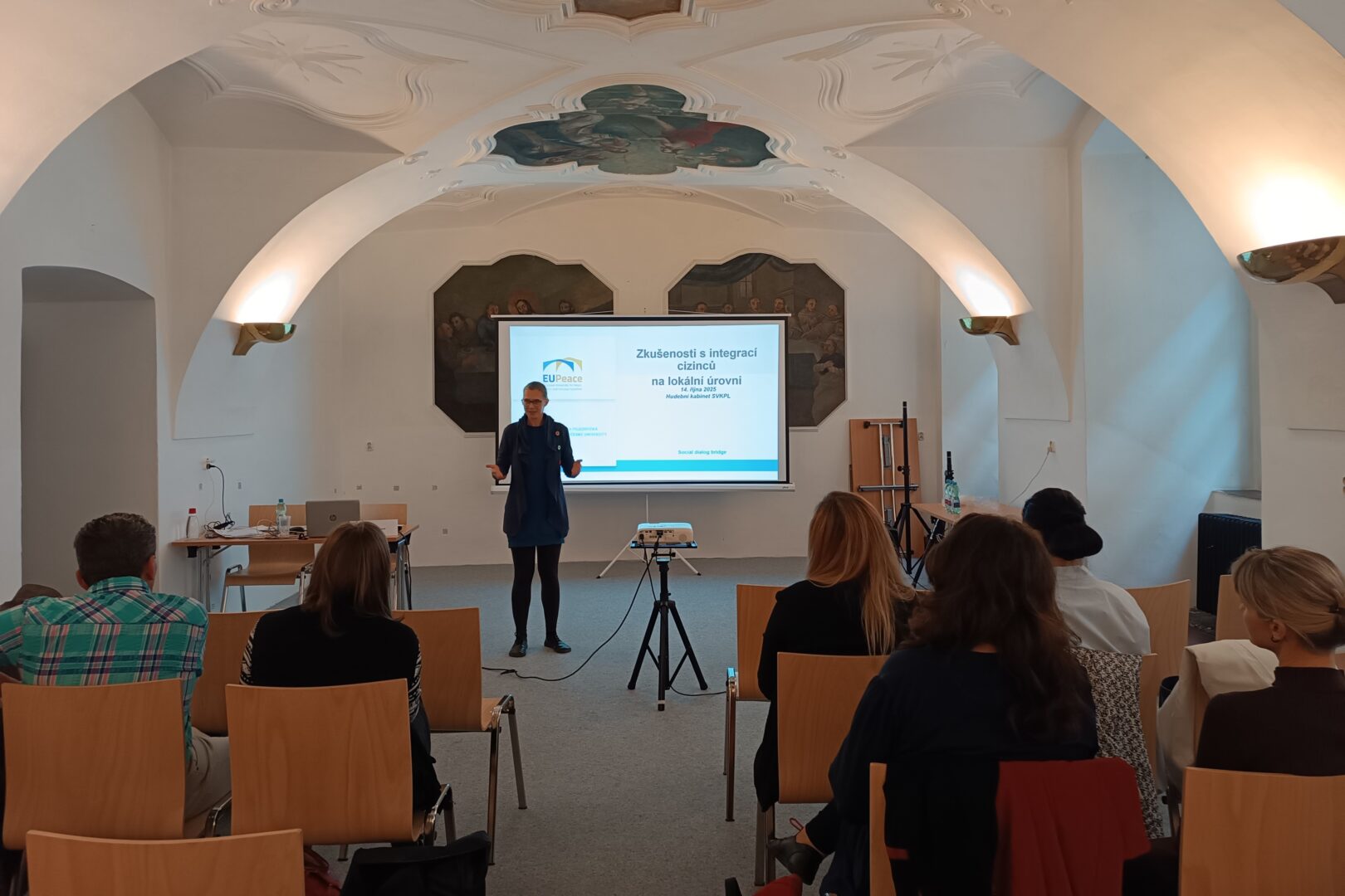 A woman is giving a lecture on Czech approach to integration of foreigners.