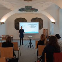 A woman is giving a lecture on Czech approach to integration of foreigners.