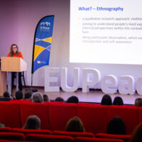 A woman stands at a podium and deliver a lecture during the Teaching Europe Conference.