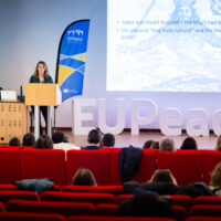 Two women stand at a podium and deliver a lecture during the Teaching Europe Conference.