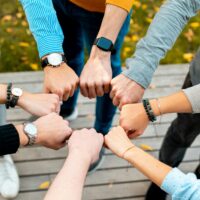 Seven hands in the form of fists held together creating a circle
