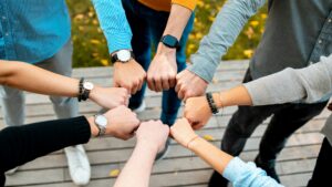Seven hands in the form of fists held together creating a circle