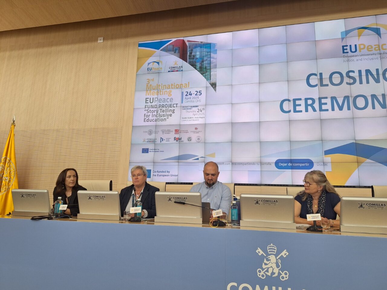 Panel of speakers at Comillas University presenting during an academic event.