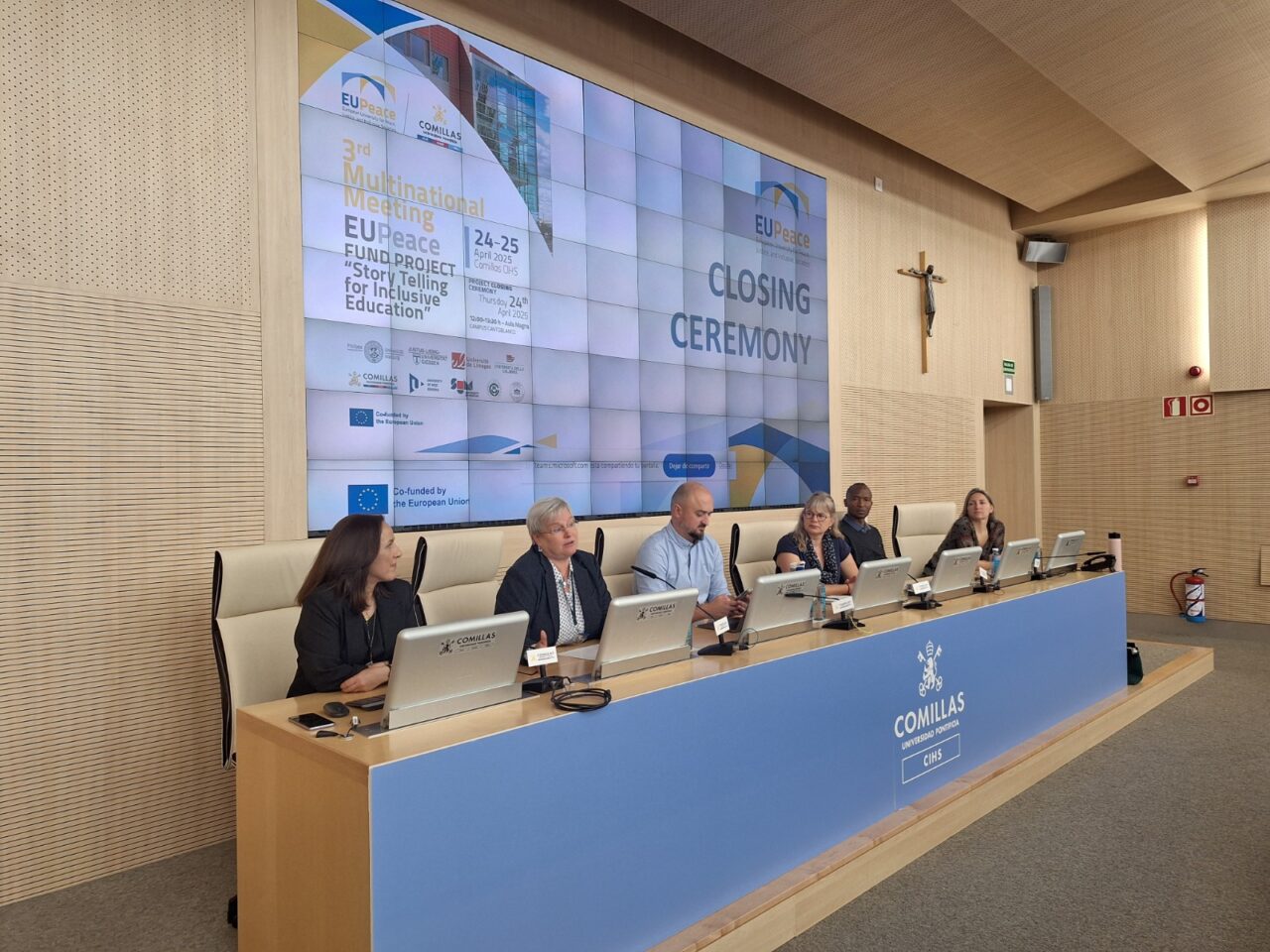 Panel of speakers at Comillas University presenting during an academic event.