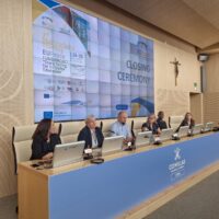 Panel of speakers at Comillas University presenting during an academic event.