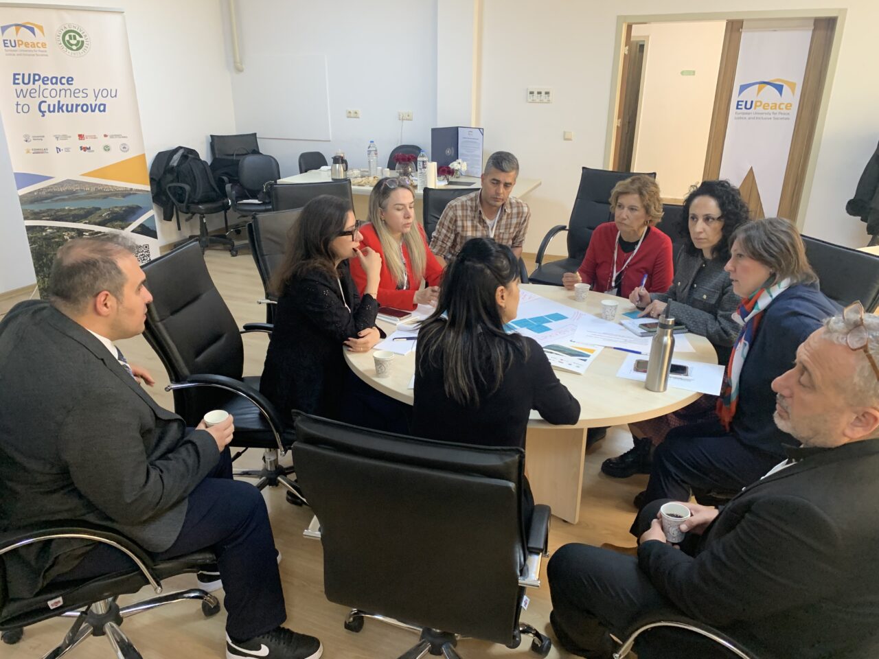 A group of professionals seated around a table discussing coordination and collaboration during a working group meeting