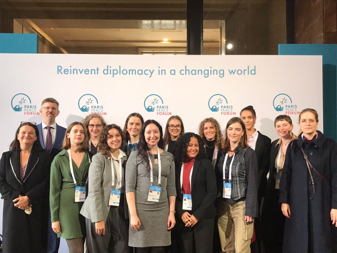 A diverse group of people representing the EUPeace delegation at the Paris Peace Forum 2025.