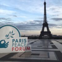 The logo of the Paris Peace Forum 2025 in front of the Eifel Tower.